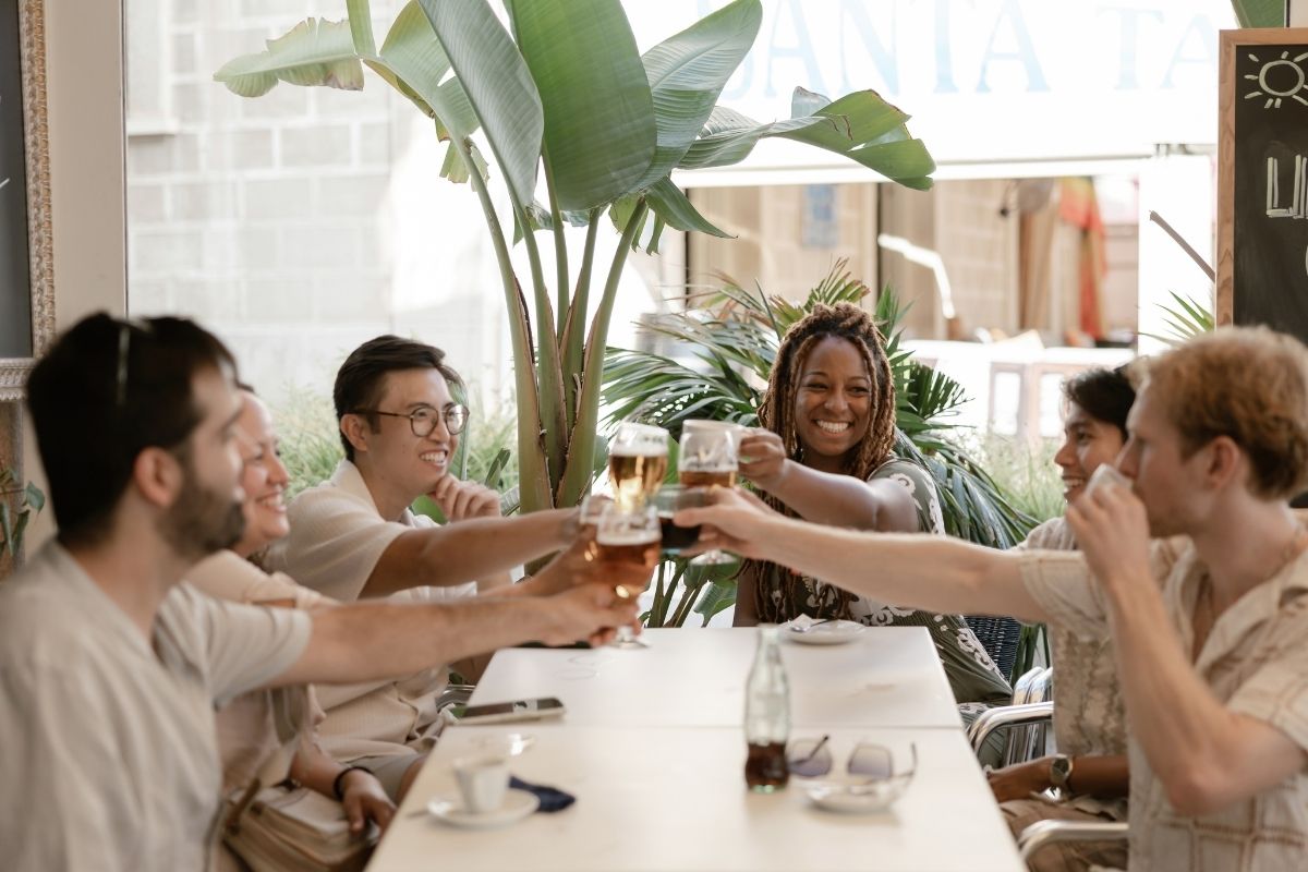 Goldenweeks group raising glasses together at a shared meal celebrating progress